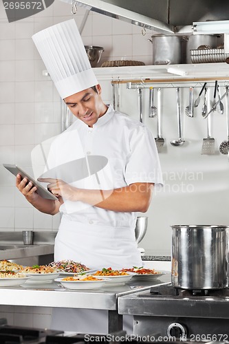 Image of Chef Using Tablet With Pasta Dishes At Counter