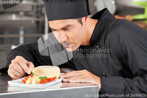 Image of Male Chef Garnishing Dish