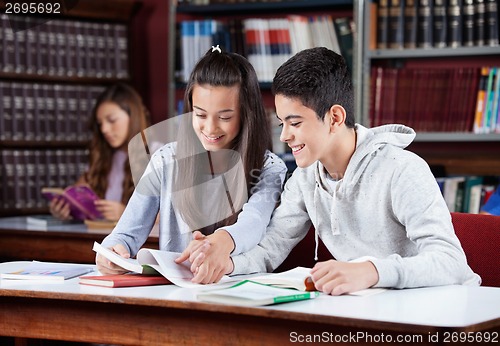 Image of Teenage Couple Studying Together In Library