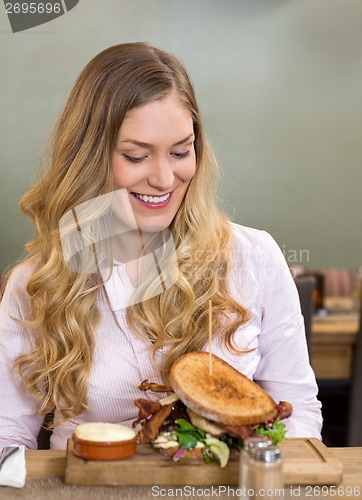 Image of Woman Looking At Burger In Restaurant