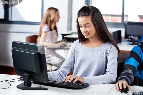 Image of Girl Using Computer With Friends In Classroom