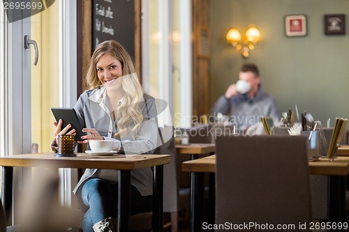 Image of Pregnant Woman Using Digital Tablet In Coffeeshop