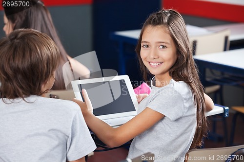Image of Schoolgirl Holding Digital Tablet At Desk