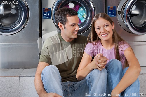 Image of Woman Holding Man's Hand At Laundromat