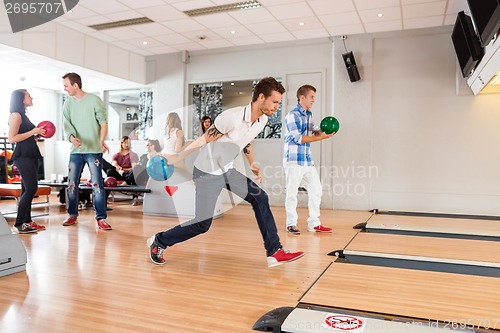 Image of People Playing in Bowling Alley