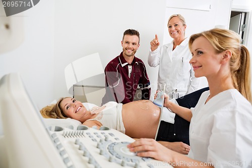 Image of Couple And Doctors Looking At Ultrasound