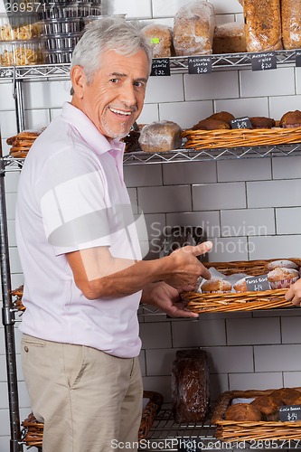 Image of Senior Man Showing Muffins In Supermarket