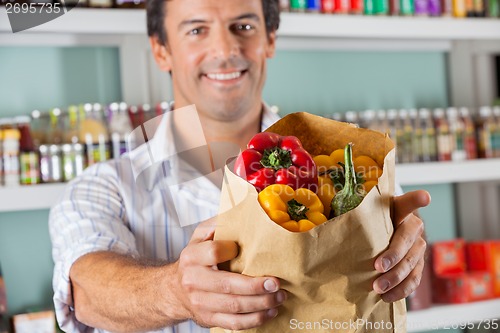 Image of Male Customer Showing Bellpeppers In Paper Bag