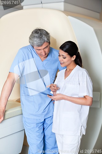 Image of Technicians Standing by MRI Machine