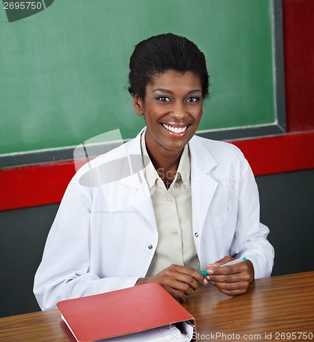 Image of Confident Female Professor Sitting At Desk