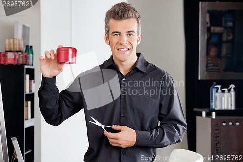 Image of Hairstylist With Scissors Presenting Hairgel Bottle