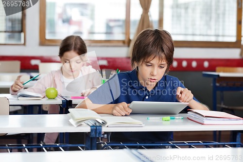 Image of Schoolboy Using Digital Tablet In Classroom