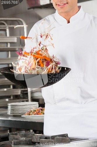 Image of Chef Flipping Vegetables in Wok