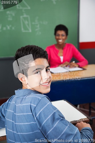 Image of Happy Teenage Schoolboy Sitting At Desk