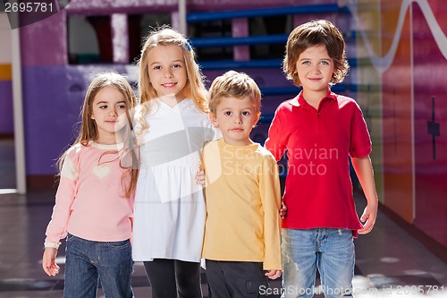 Image of Children Standing Arms Around In Kindergarten