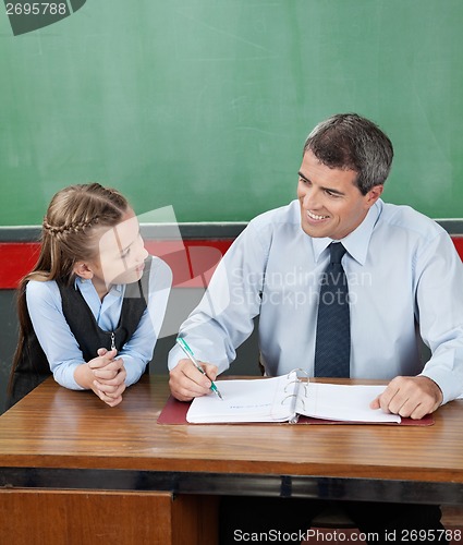 Image of Professor And Little Girl Looking At Each Other At Desk