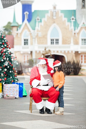 Image of Santa Claus Showing Digital Tablet To Girl