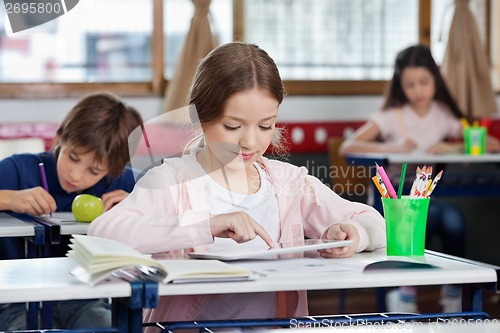 Image of Schoolgirl Using Digital Tablet At Desk