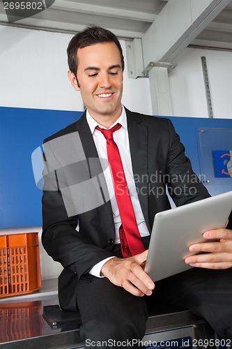 Image of Businessman Using Digital Tablet In Laundry