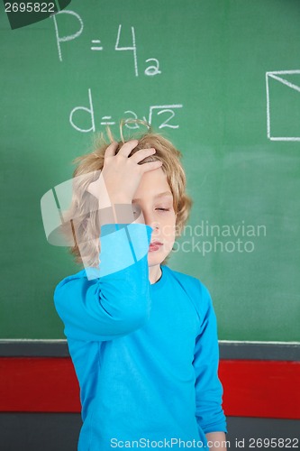 Image of Sad Schoolboy Standing By Board In Classroom