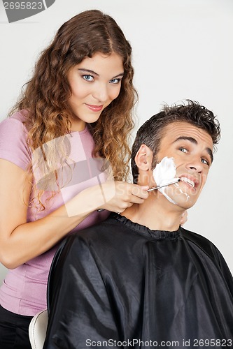Image of Scared Man Being Shaved By Female Barber