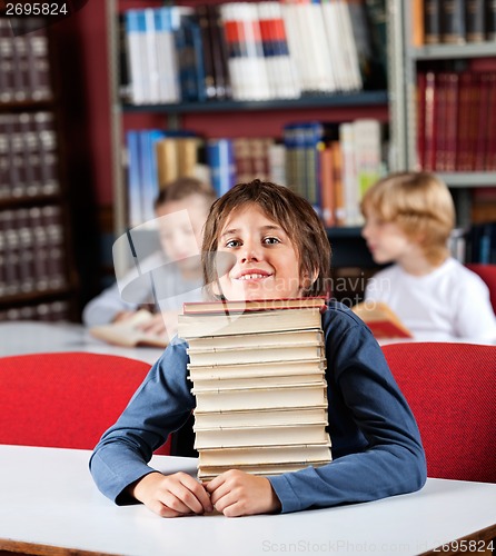 Image of Schoolboy Resting Chin On Stack Of Books