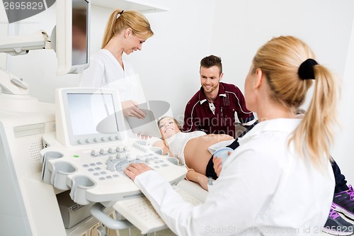 Image of Doctor Showing Digital Tablet To Expectant Couple