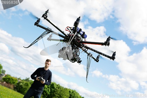 Image of Technician Flying UAV Helicopter in Park