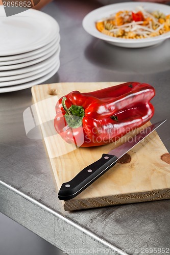 Image of Red Bellpepper And Knife On Cutting Board