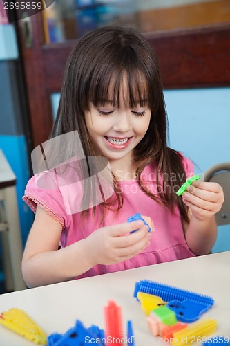 Image of Girl Playing With Construction Blocks In Classroom