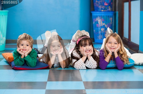 Image of Children Lying In A Row On Floor In Classroom