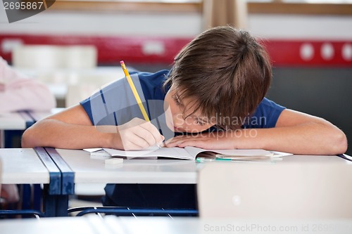 Image of Elementary Boy Writing At Desk