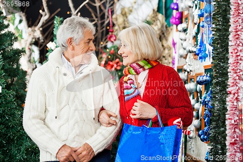 Image of Senior Couple With Shopping Bags At Christmas Store