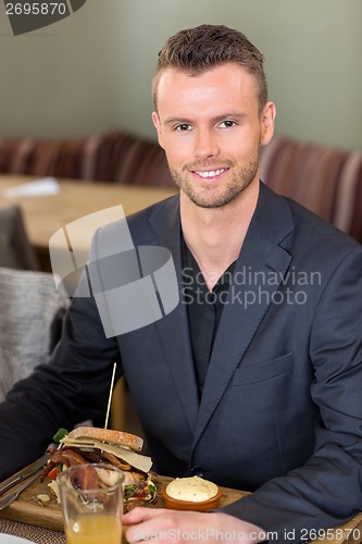 Image of Young Businessman With Sandwich And Juice