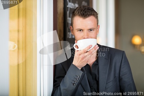 Image of Young Businessman Drinking Coffee