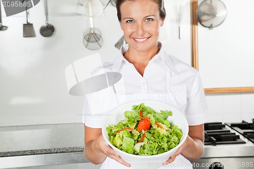 Image of Female Chef Presenting Bowl Of Salad