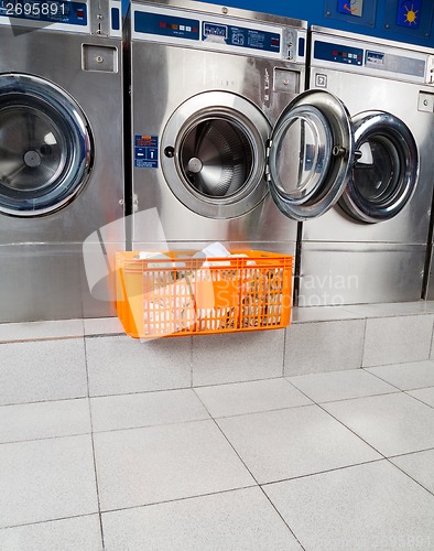 Image of Basket Of Clothes In Front Of Washing Machine