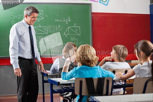 Image of Teacher Looking At Students Sitting In Classroom