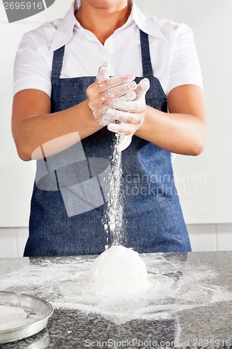 Image of Female Chef Adding Flour To Dough