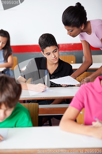 Image of Teacher Showing Paper To University Student