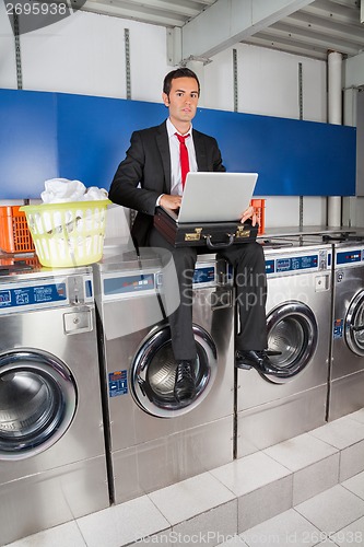 Image of Businessman With Laptop In Laundry