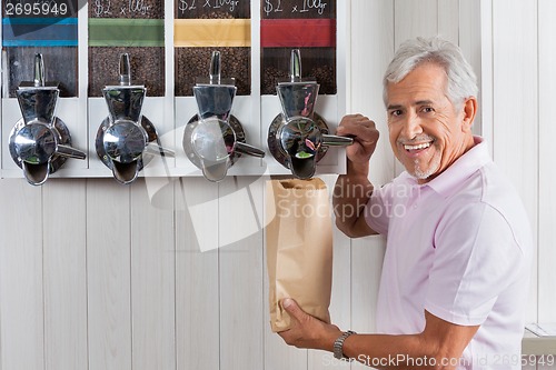 Image of Senior Man Buying Coffee Beans From Vending Machine