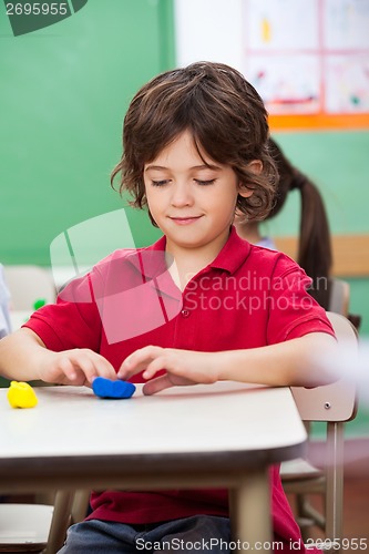 Image of Boy Molding Clay At Desk