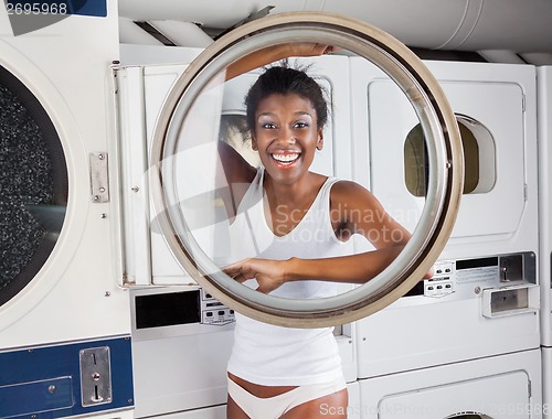 Image of Woman Looking Through Washing Machine Door