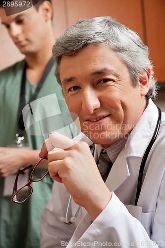 Image of Mature Doctor Holding Glasses