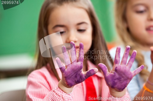 Image of Girl Looking At Colored Hands In Art Class