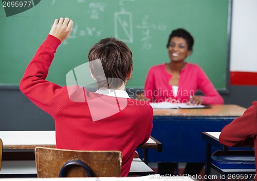 Image of Schoolboy Raising Hand In Classroom