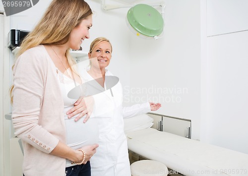 Image of Gynecologist Gesturing To Pregnant Woman