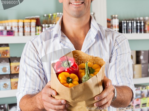 Image of Male Customer Showing Bellpeppers In Paper Bag