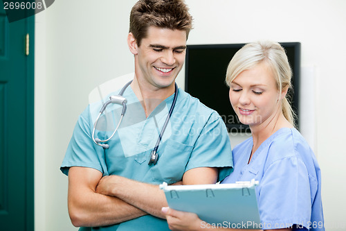 Image of Young Female Nurse Showing Clipboard To Male Vet